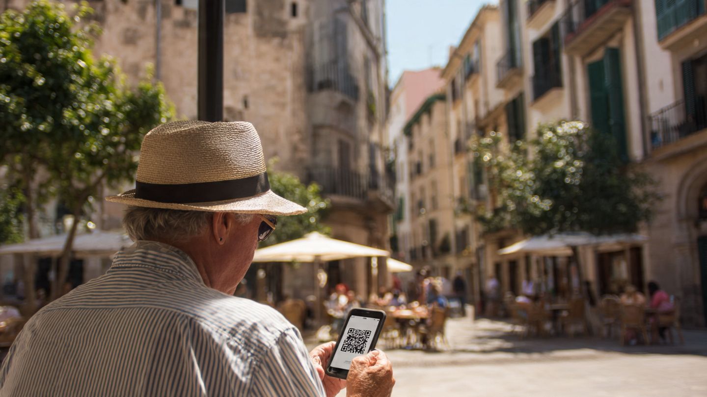 A traveler at Palma de Mallorca’s historic center scanning an eSIM QR code on their smartphone; bright afternoon sun, lively street atmosphere