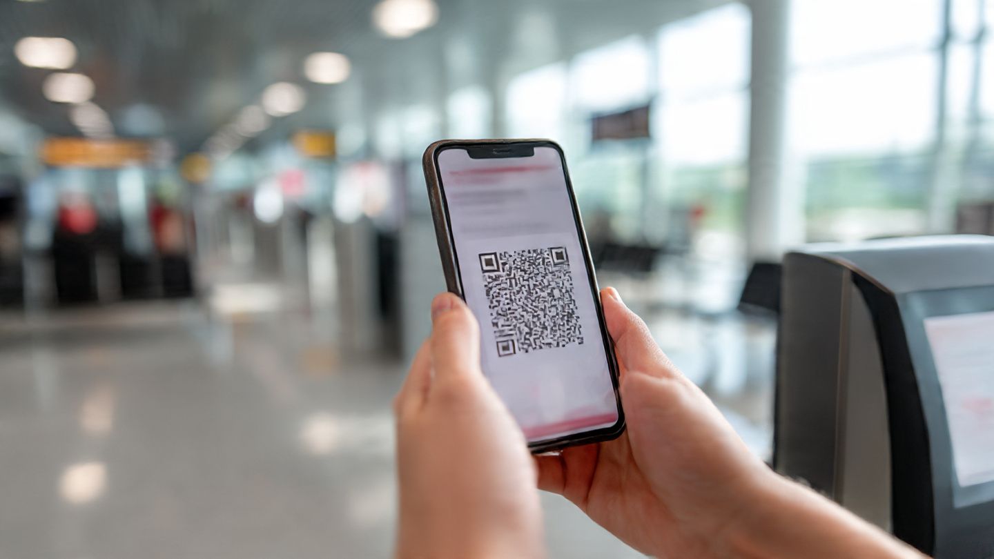 Digital traveler scanning eSIM QR code at Belgrade airport terminal; bright, modern tech environment with phone screen visible; purpose: demonstrate quick and easy eSIM setup process for Serbia.