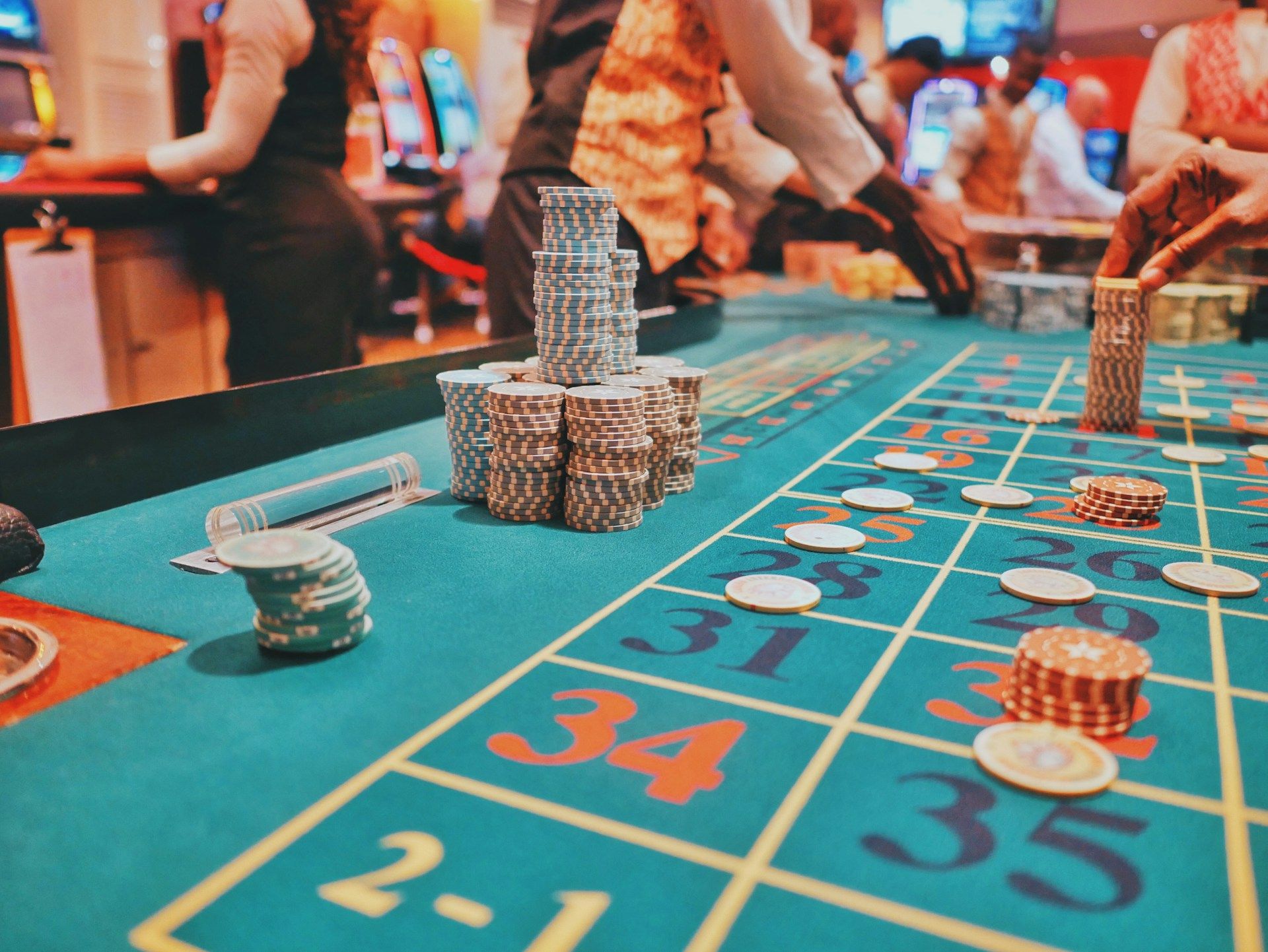 Mesa de ruleta con montones de fichas y jugadores en acción