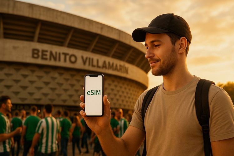 Traveler outside Estadio Benito Villamarín holding smartphone showing active Spain eSIM profile