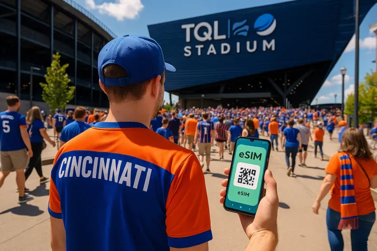MLS fan walking toward TQL Stadium in Cincinnati with phone showing active eSIM
