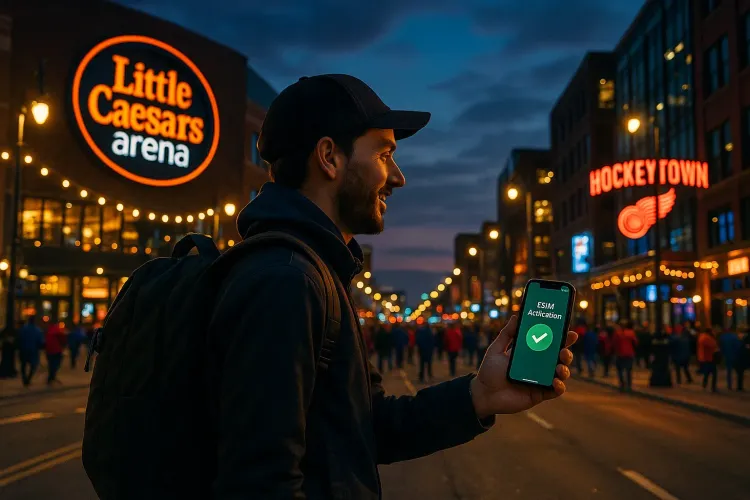 Traveler walking outside Little Caesars Arena in Detroit at dusk