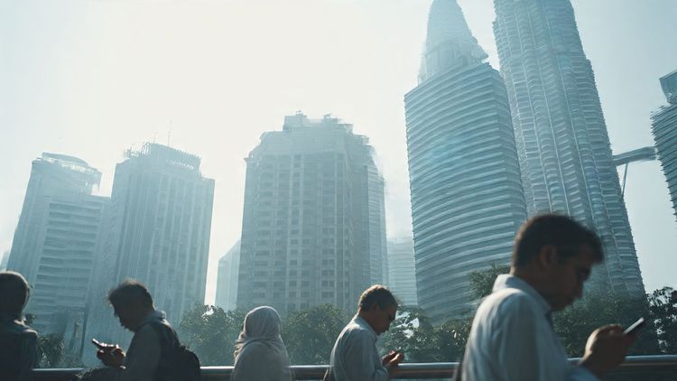 A bustling Kuala Lumpur cityscape with business travelers using mobile devices outside a summit venue, captured in a clean editorial documentary style