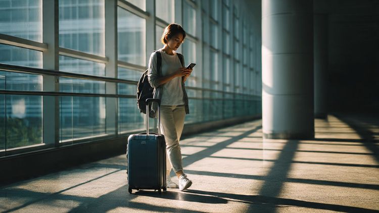 A modern traveler rolling luggage through Singapore Changi Airport, scanning a phone with a digital eSIM interface, bright natural lighting, clean futuristic setting, helpful relocation tone.
