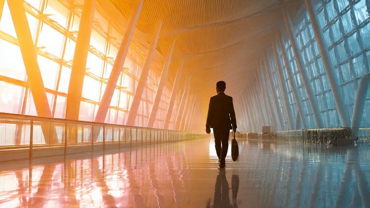 A professional business traveler walking through an international airport terminal, warm lighting, modern architecture, emphasizing connectivity during large conferences like APEC 2025