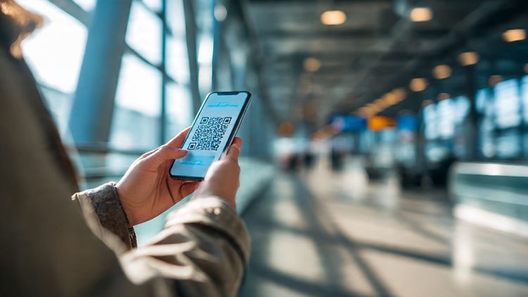 A traveler holding an iPhone at an airport, scanning an eSIM QR code with natural daylight and a clean tech-oriented aesthetic; meant to visually represent easy iPhone eSIM setup during international travel