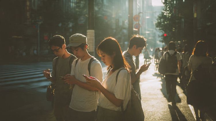 An early-morning Tokyo street with travelers checking phones for directions, soft cinematic light, editorial travel photography style, meant to visually support the idea of reliable connectivity in Japan travel.