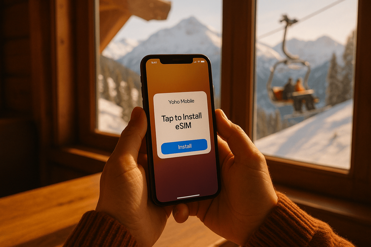 A traveler easily installing a Yoho Mobile eSIM on their iPhone inside a ski lodge before hitting the slopes.