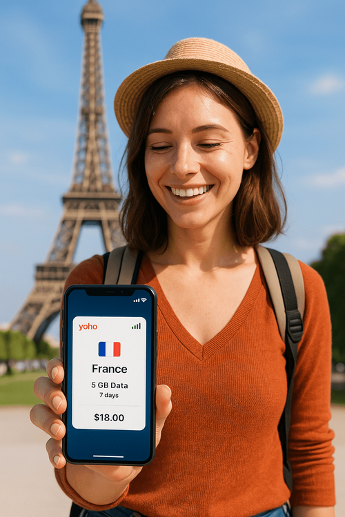 A happy traveler uses her Yoho Mobile eSIM data plan on her phone while visiting the Eiffel Tower in Paris.