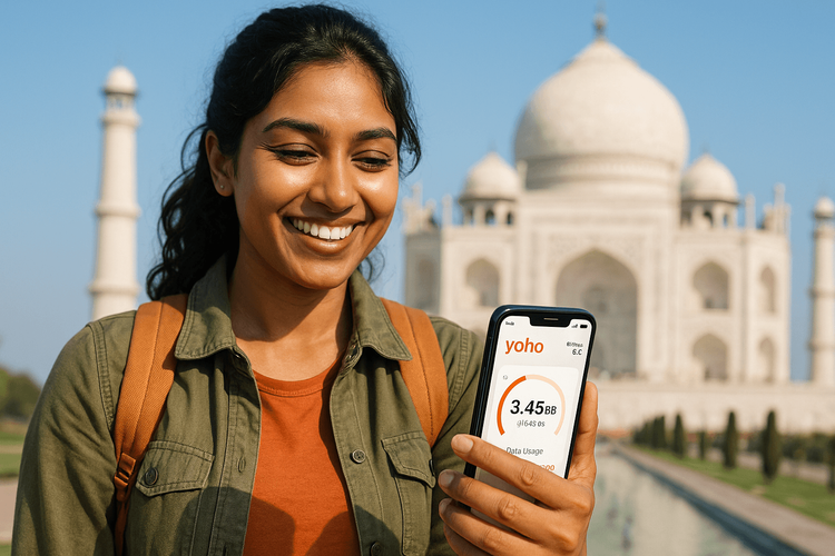 A traveler using a Yoho Mobile eSIM on her phone with the Taj Mahal in the background, showcasing seamless connectivity in India.