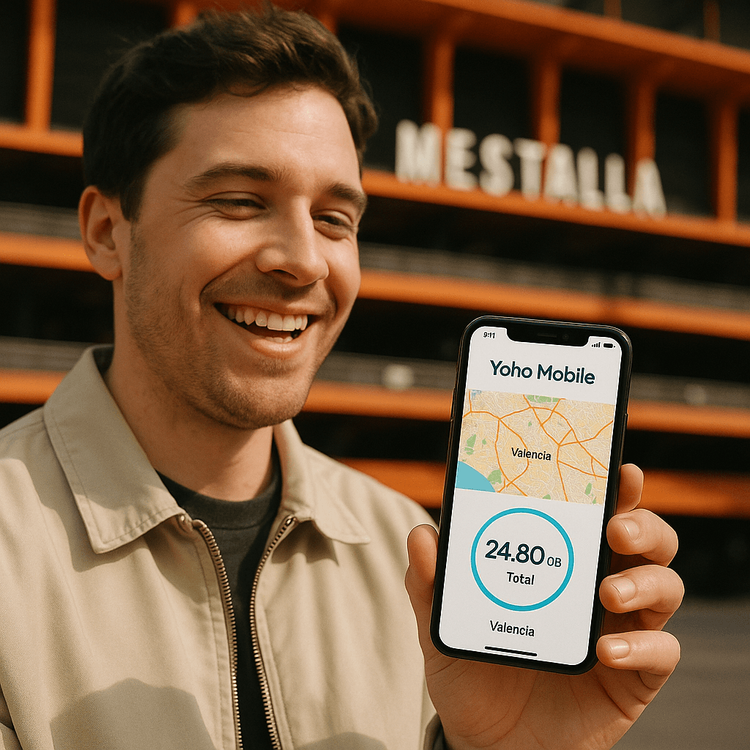 A happy football fan using a Yoho Mobile eSIM on their phone outside Mestalla stadium in Valencia.