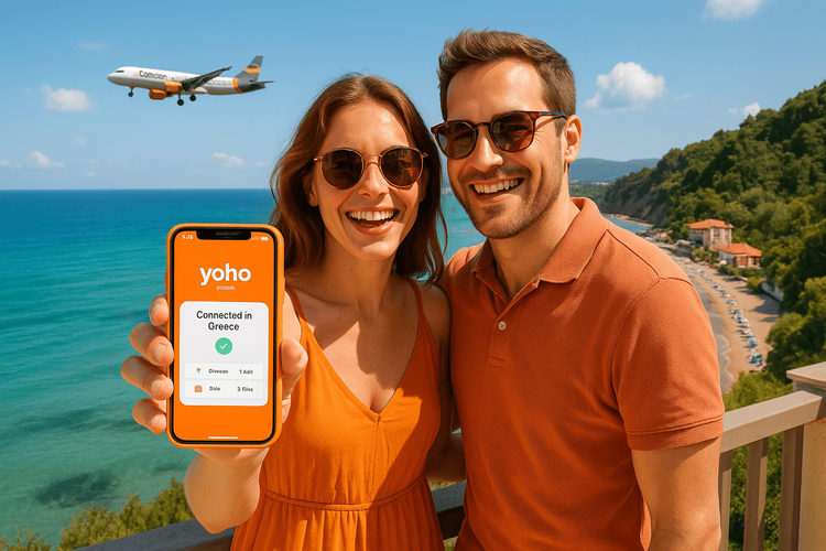 A happy couple on a Corfu balcony using a Yoho Mobile eSIM for Greece after their Condor flight.