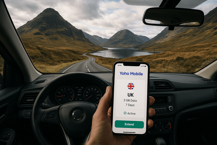 A person using a Yoho Mobile eSIM on their phone while on a road trip through the scenic Scottish Highlands.