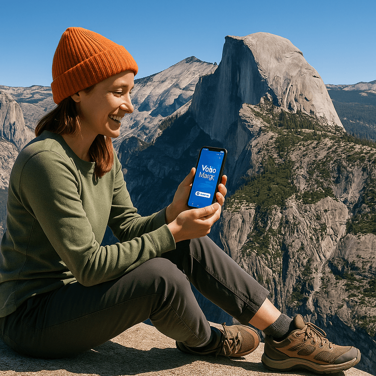 A traveler using a smartphone with a strong signal in Yosemite National Park, demonstrating reliable travel connectivity.