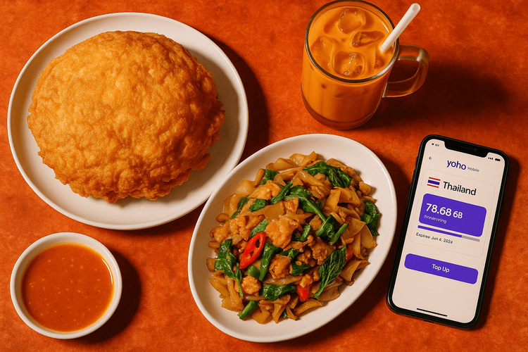 A table at Jay Fai with the famous crab omelette and a phone displaying the Yoho Mobile eSIM app.