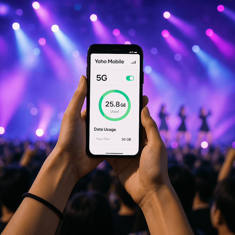 A fan at a K-pop concert holding a smartphone with the Yoho Mobile app, showing a strong 5G signal.