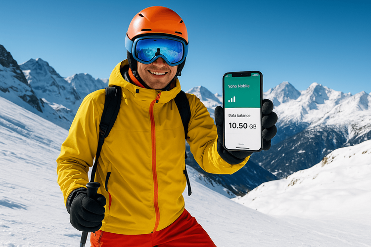 A skier using a Yoho Mobile eSIM on their smartphone to stay connected on a sunny slope in the Alps.