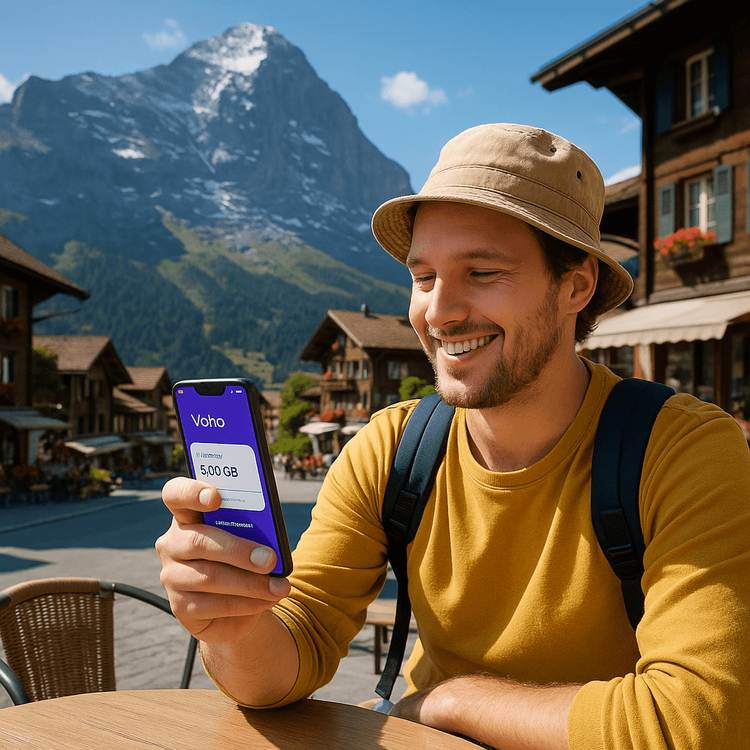 A traveler enjoying seamless connectivity with a Yoho Mobile eSIM while admiring the Swiss Alps.