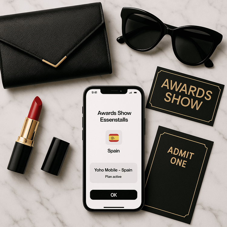 A flat lay of essentials for an awards show trip, including a phone with a Yoho Mobile eSIM ready for use.