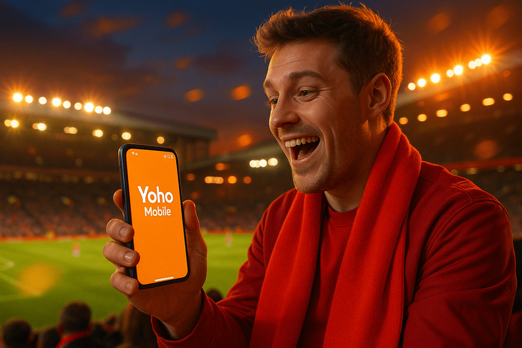 A football fan using a Yoho Mobile eSIM on their smartphone at a Premier League match in the UK.