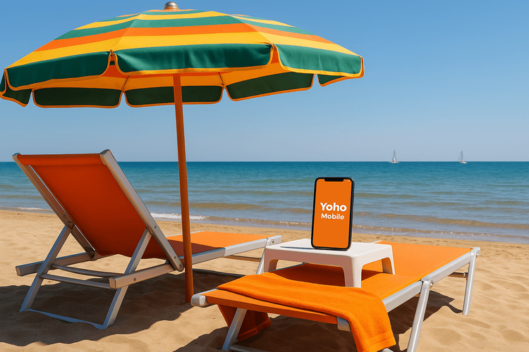 A sunny beach in Rimini, Italy, with a smartphone showing the Yoho Mobile eSIM app, ready for a connected holiday.