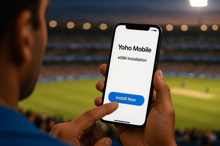 A person easily installing a Yoho Mobile eSIM on their smartphone with a cricket stadium in the background.