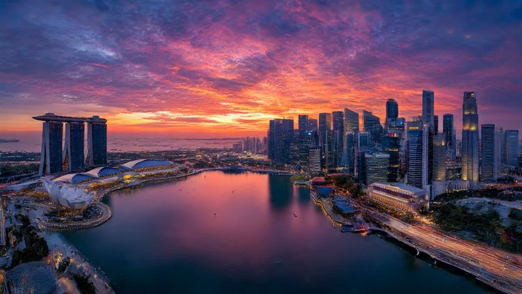 High-resolution aerial view of Singapore’s Marina Bay skyline at sunrise, vibrant colors, modern futuristic atmosphere, travel photography style; image meant to represent seamless travel connectivity