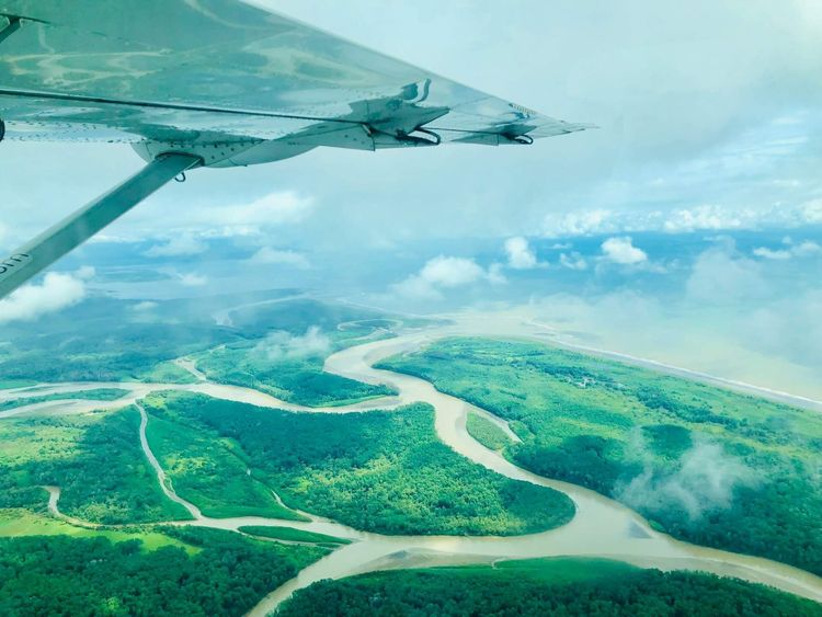 Costa Rica airports: A scenic aerial view of winding rivers and lush greenery from an airplane wing