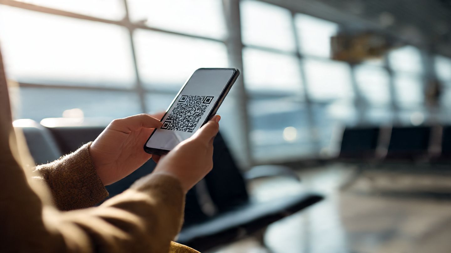 Traveler scanning a QR code on a smartphone in an airport lounge, preparing for NBA game travel, modern tech convenience, bright travel mood