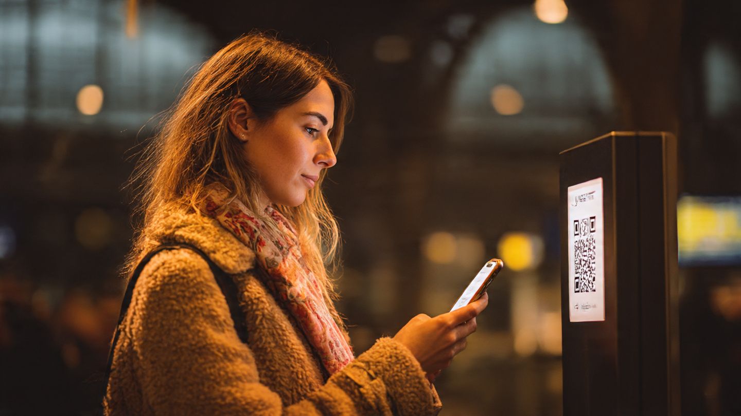 Traveler scanning an eSIM QR code in Zurich's central train station, warm lighting, modern travel-focused aesthetic