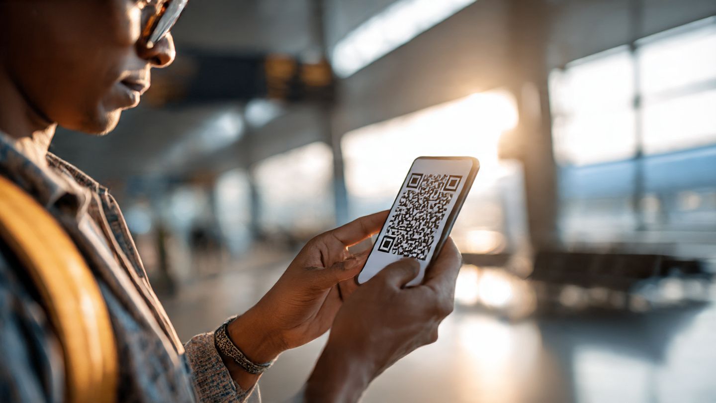 Traveler scanning eSIM QR code in bright airport setting, tech confidence vibe, purpose: demonstrate simple and private activation process